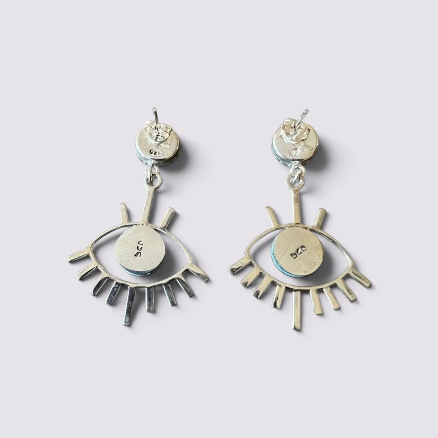 The Fashion Jewels sterling silver evil eye earrings with turquoise accents and 925 hallmark on a light background