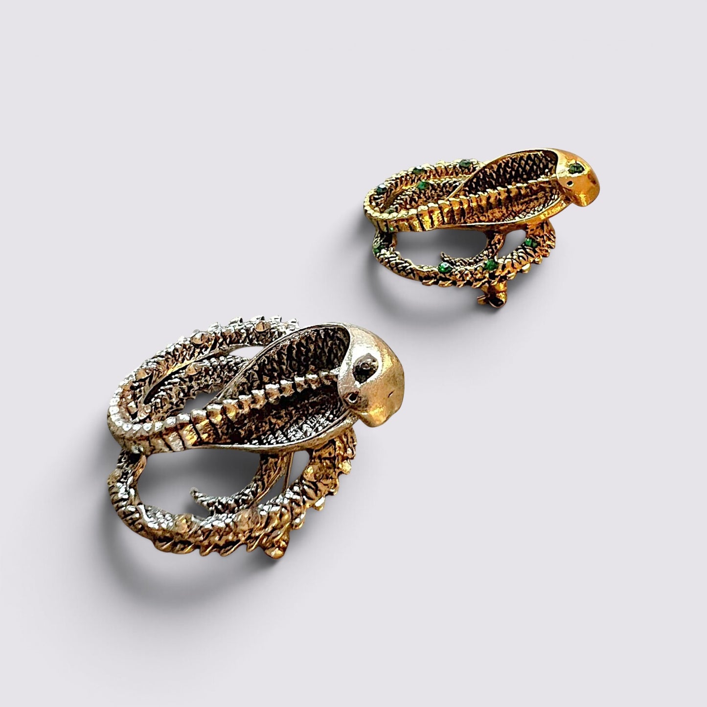 The Fashion Jewels cobra serpent statement brooch pins in gold and silver tones with intricate textured detailing.