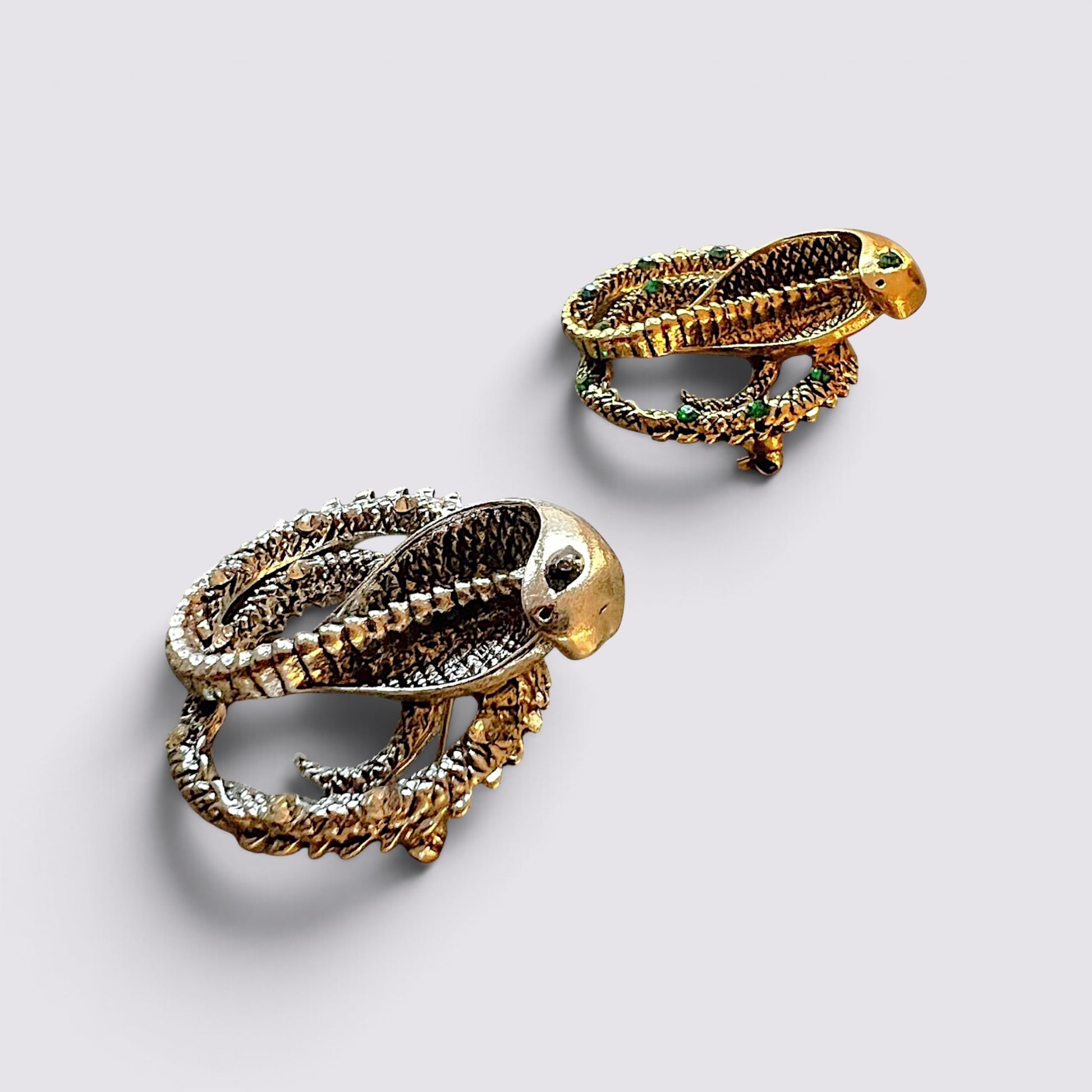 The Fashion Jewels cobra serpent statement brooch pins in gold and silver tones with intricate textured detailing.