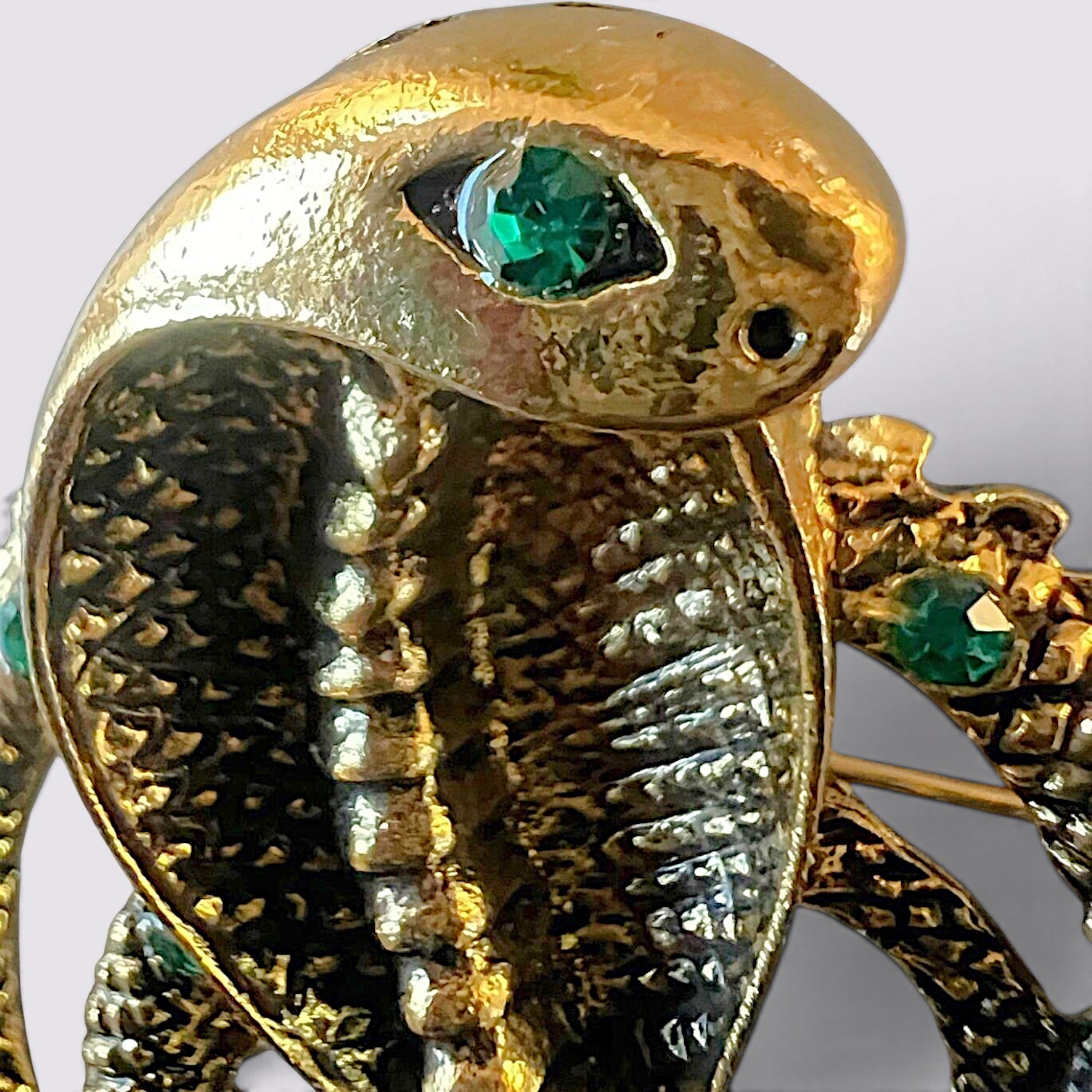 The Fashion Jewels gold cobra brooch with textured scales and vibrant green crystal eyes for a statement accessory.