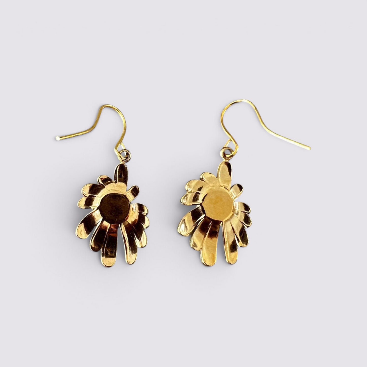 The Fashion Jewels floral drop earrings featuring a polished gold-tone sunburst petal design and green stone center.