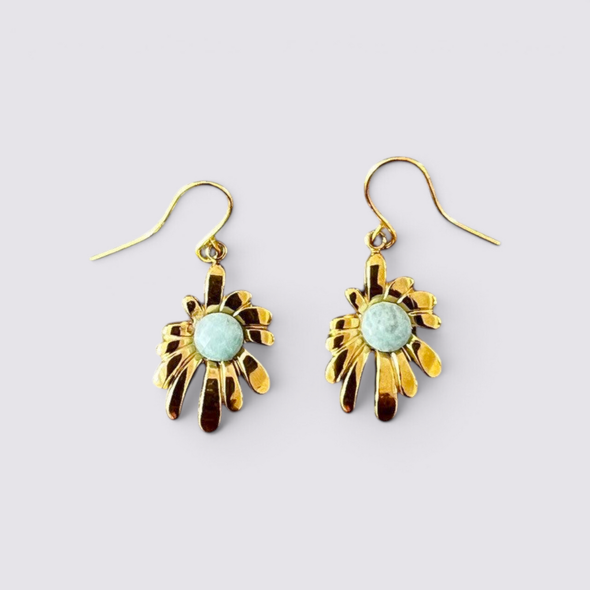 The Fashion Jewels floral drop earrings featuring polished gold-tone petals and a central faceted green stone.