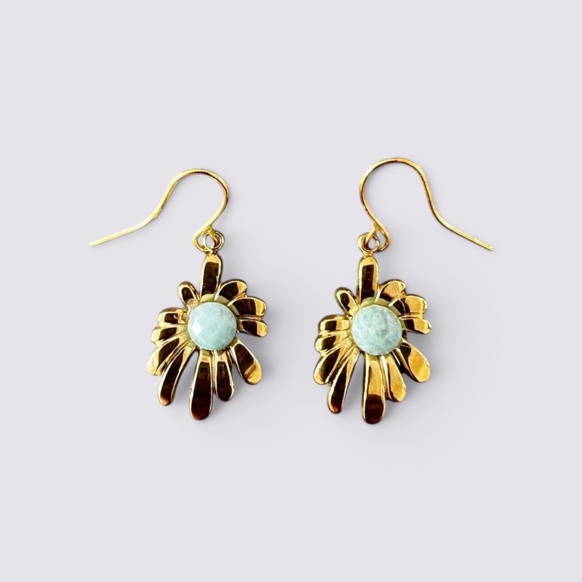 The Fashion Jewels floral drop earrings featuring polished gold-tone petals and a faceted green stone center.
