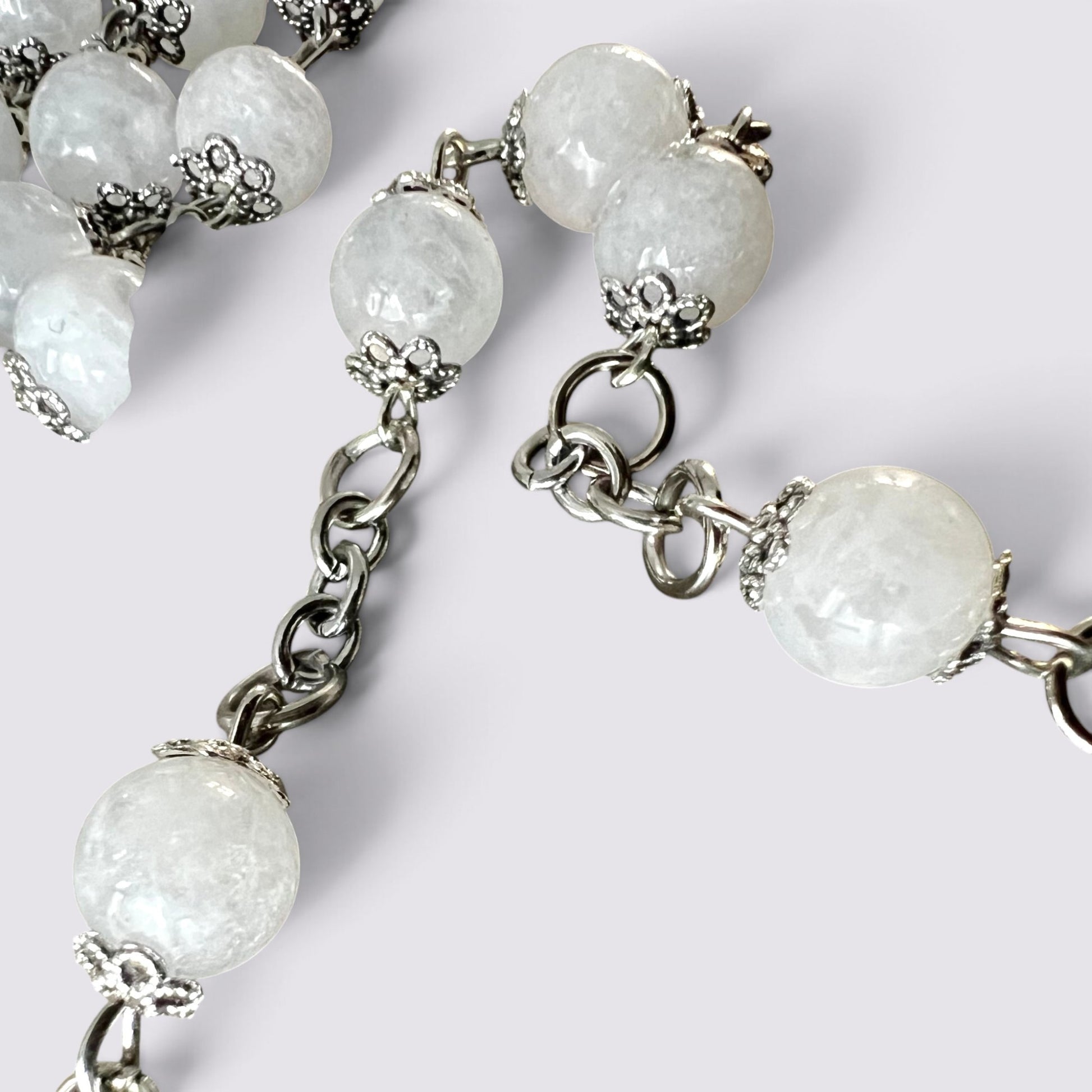 The Fashion Jewels handcrafted rosary featuring luminous moonstone beads with ornate silver-tone caps and metal chain.