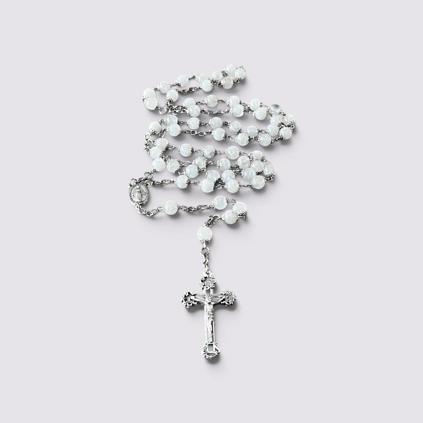 The Fashion Jewels handcrafted rosary featuring luminous moonstone beads, silver-tone metalwork, and an ornate crucifix.