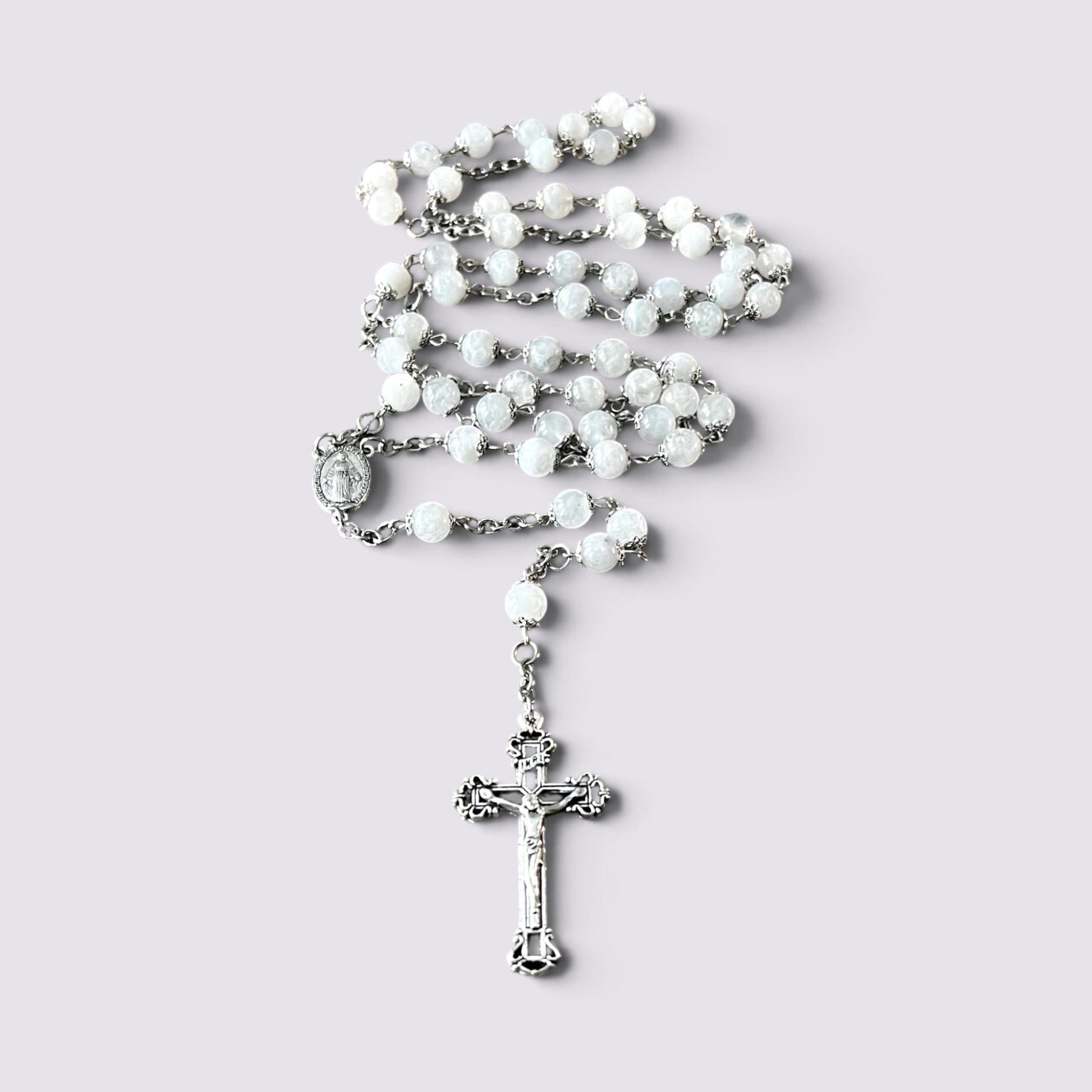 The Fashion Jewels handcrafted rosary featuring luminous moonstone beads, silver-tone metalwork, and an ornate crucifix.