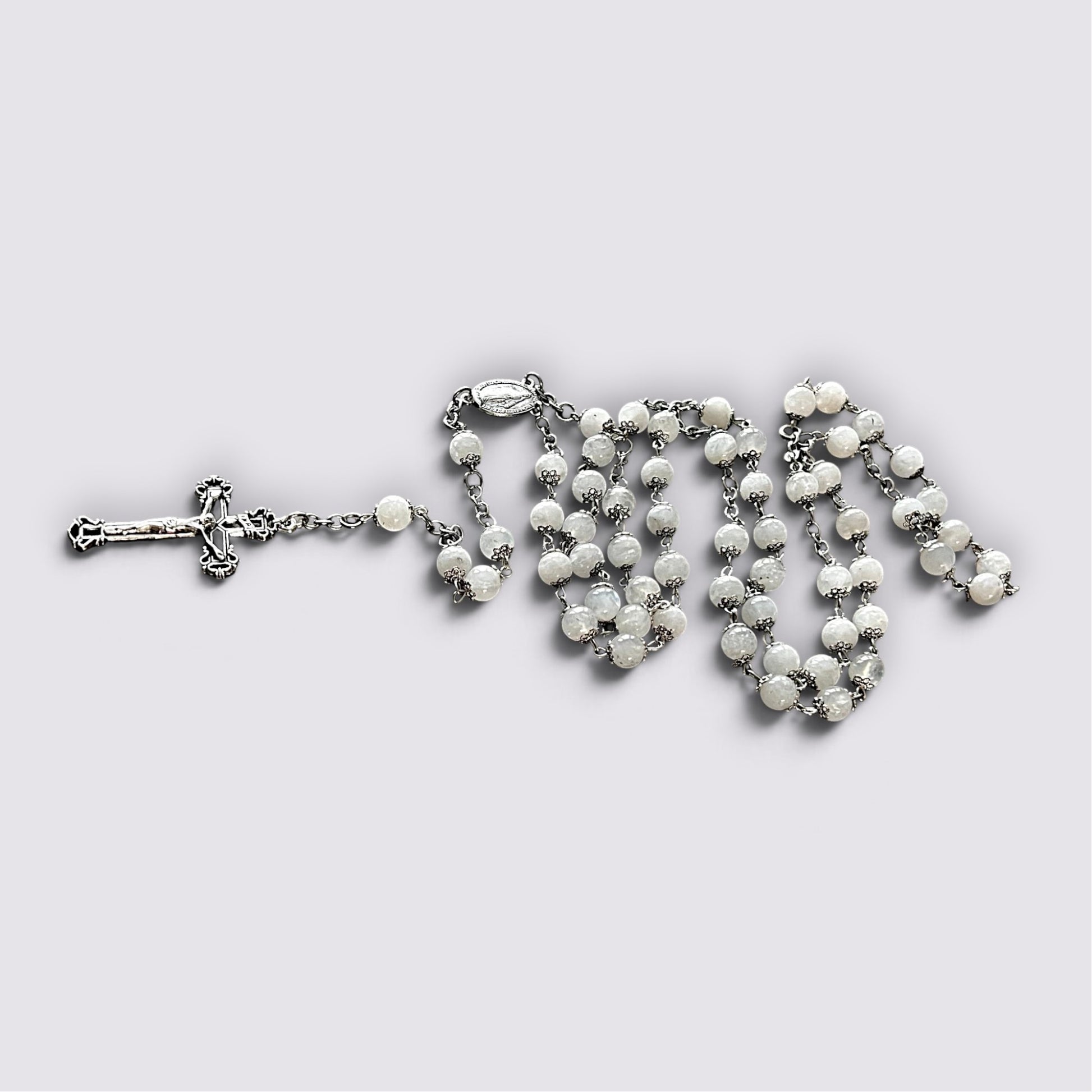The Fashion Jewels handcrafted rosary featuring luminous moonstone beads, silver-tone metalwork, and ornate crucifix.