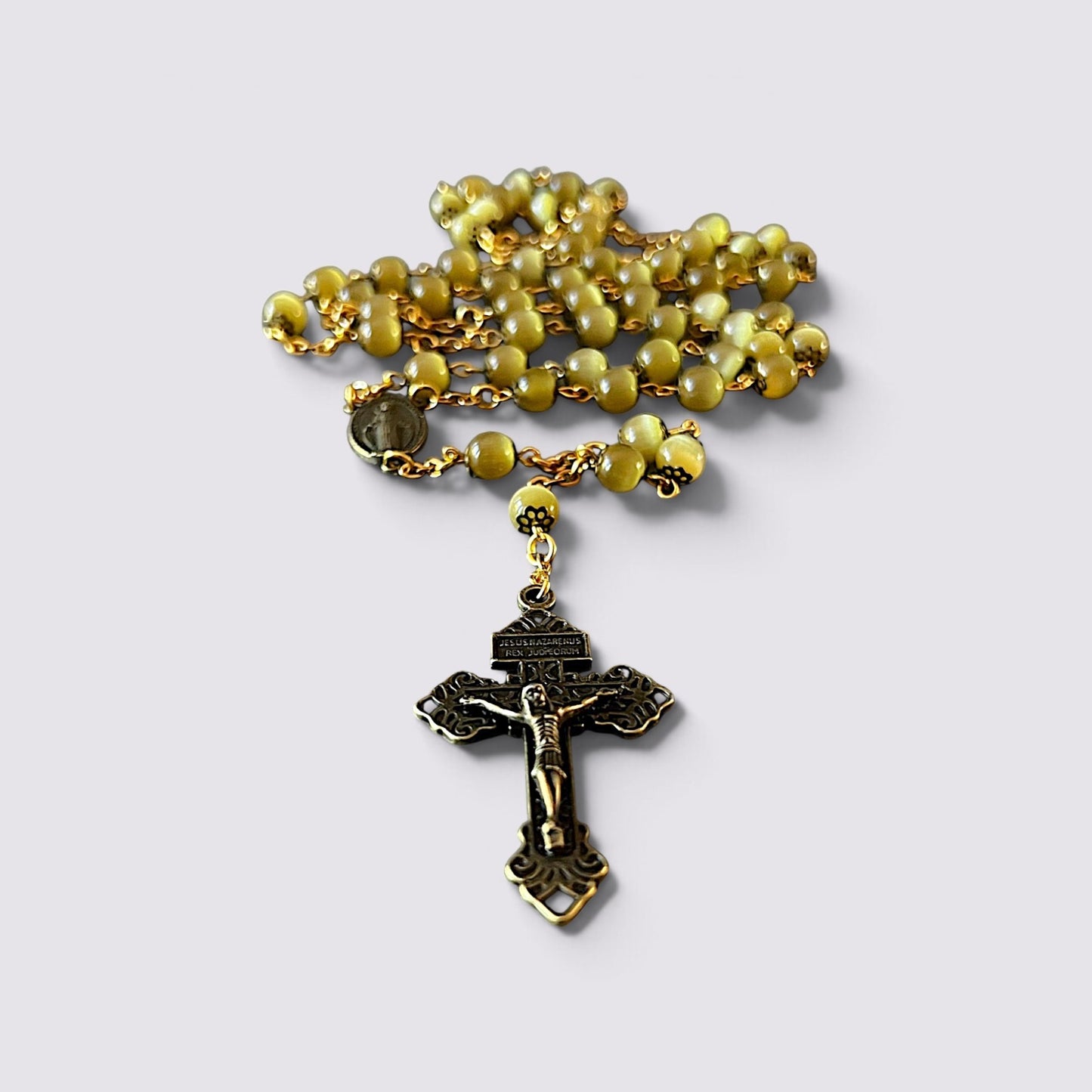 The Fashion Jewels olive cat's eye bead rosary with antique-style gold metal crucifix and Miraculous Medal centerpiece.