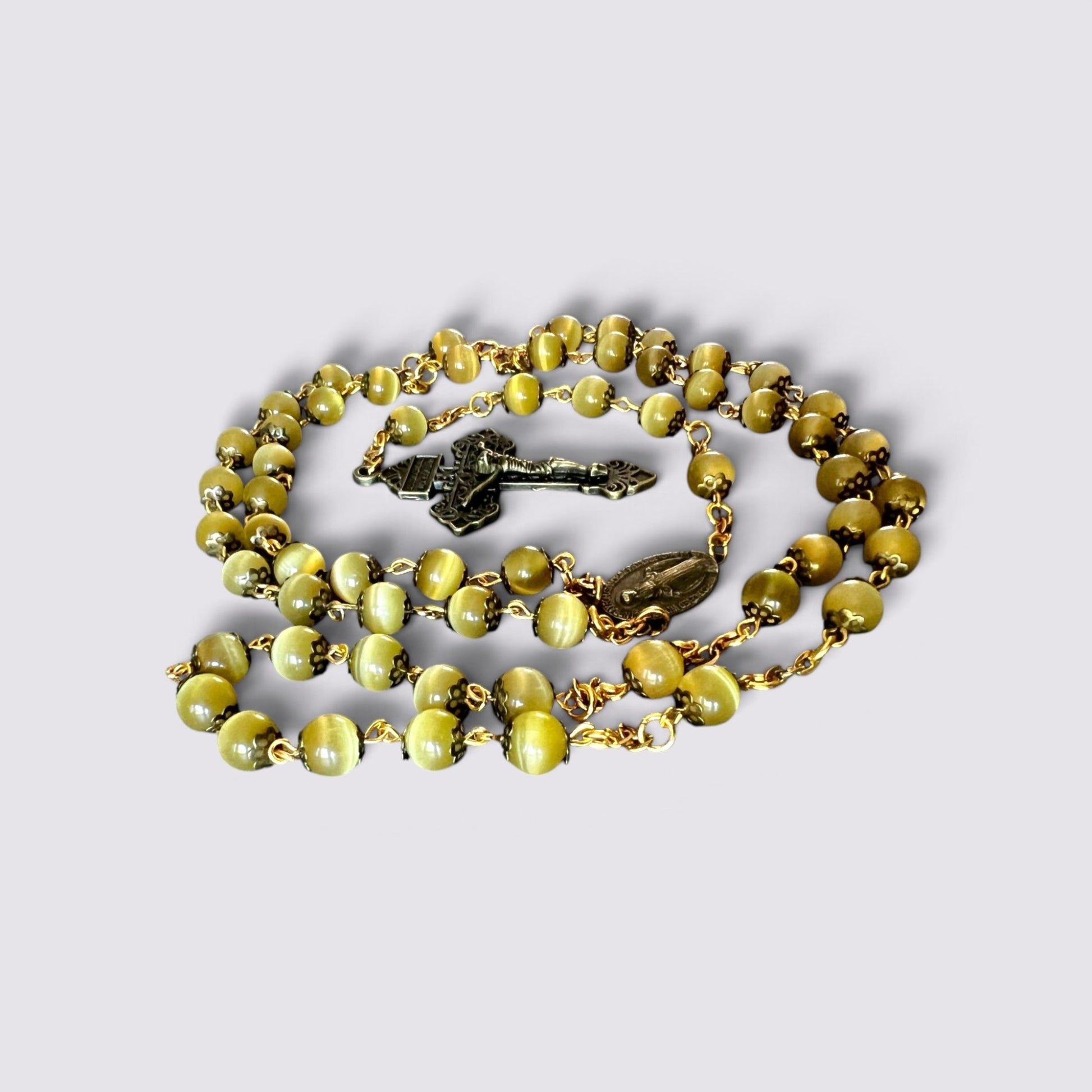 The Fashion Jewels olive cat's eye bead rosary with antique gold-tone metal caps, crucifix, and Miraculous Medal.