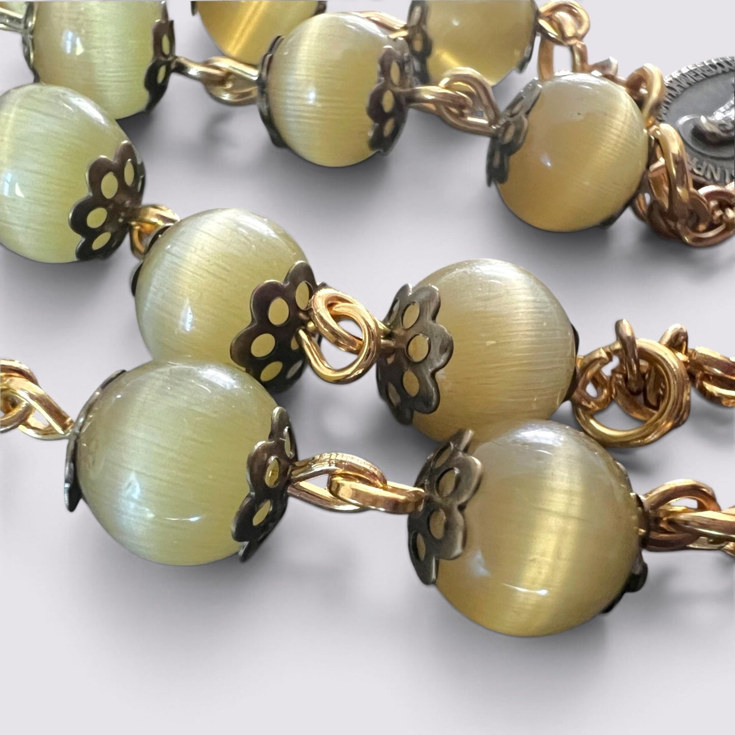 The Fashion Jewels olive cat's eye bead rosary with antique-style metal caps and gold-toned chain links.