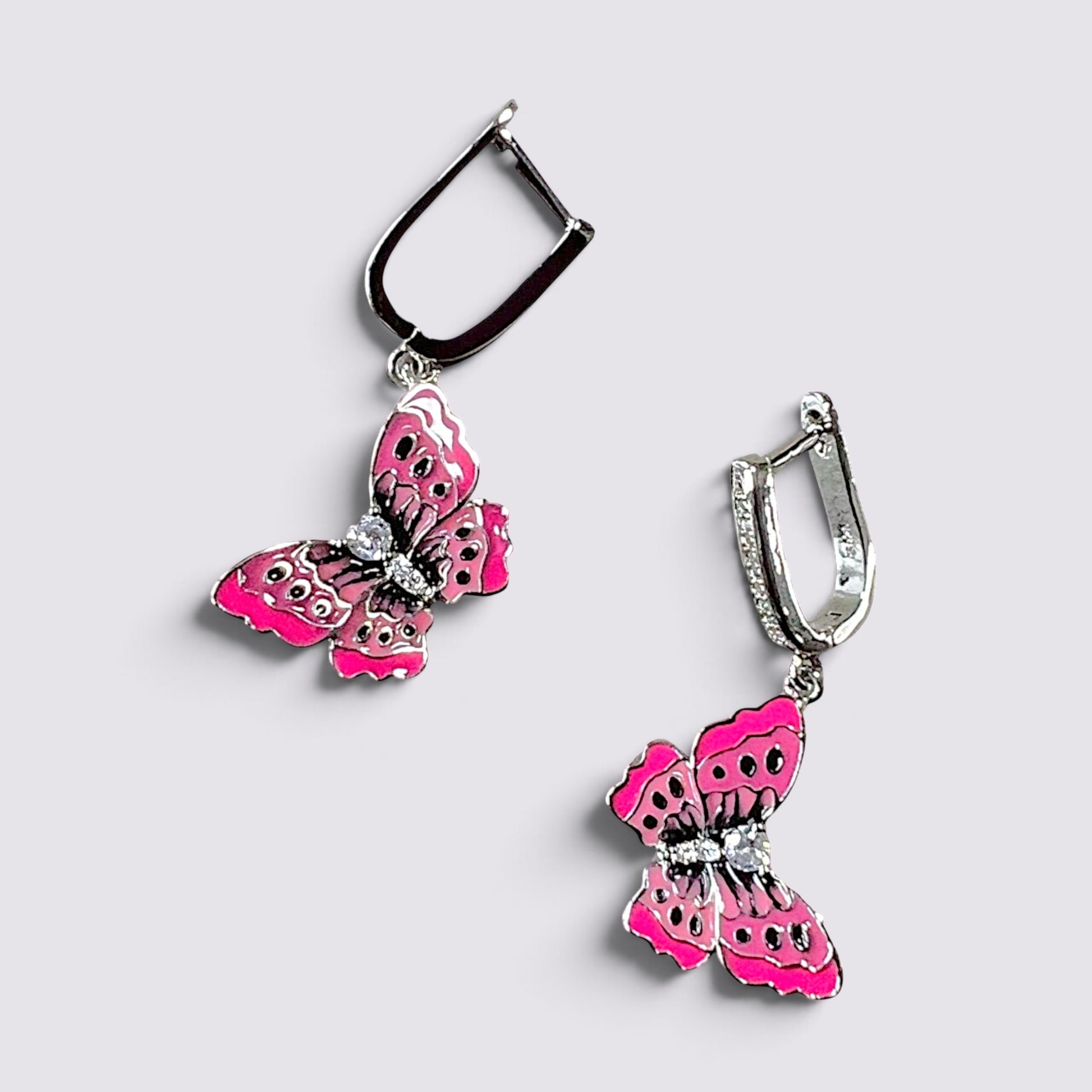 The Fashion Jewels pink enameled butterfly drop earrings with sparkling crystal accents and polished silver hardware.