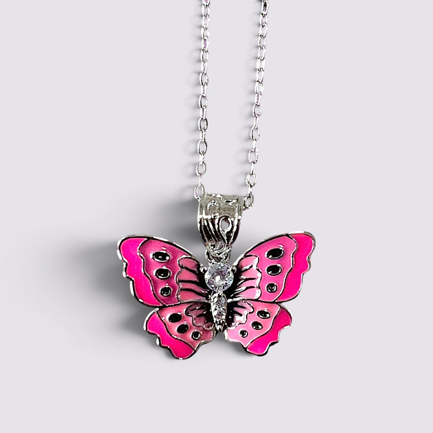 The Fashion Jewels pink enameled butterfly pendant necklace with clear stone accents on a silver-tone chain.