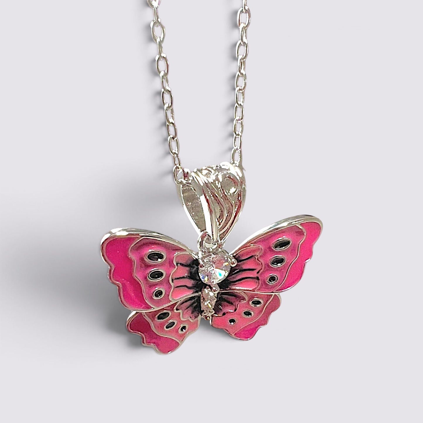 The Fashion Jewels pink enameled butterfly pendant necklace with clear stone accents on a silver-tone chain.