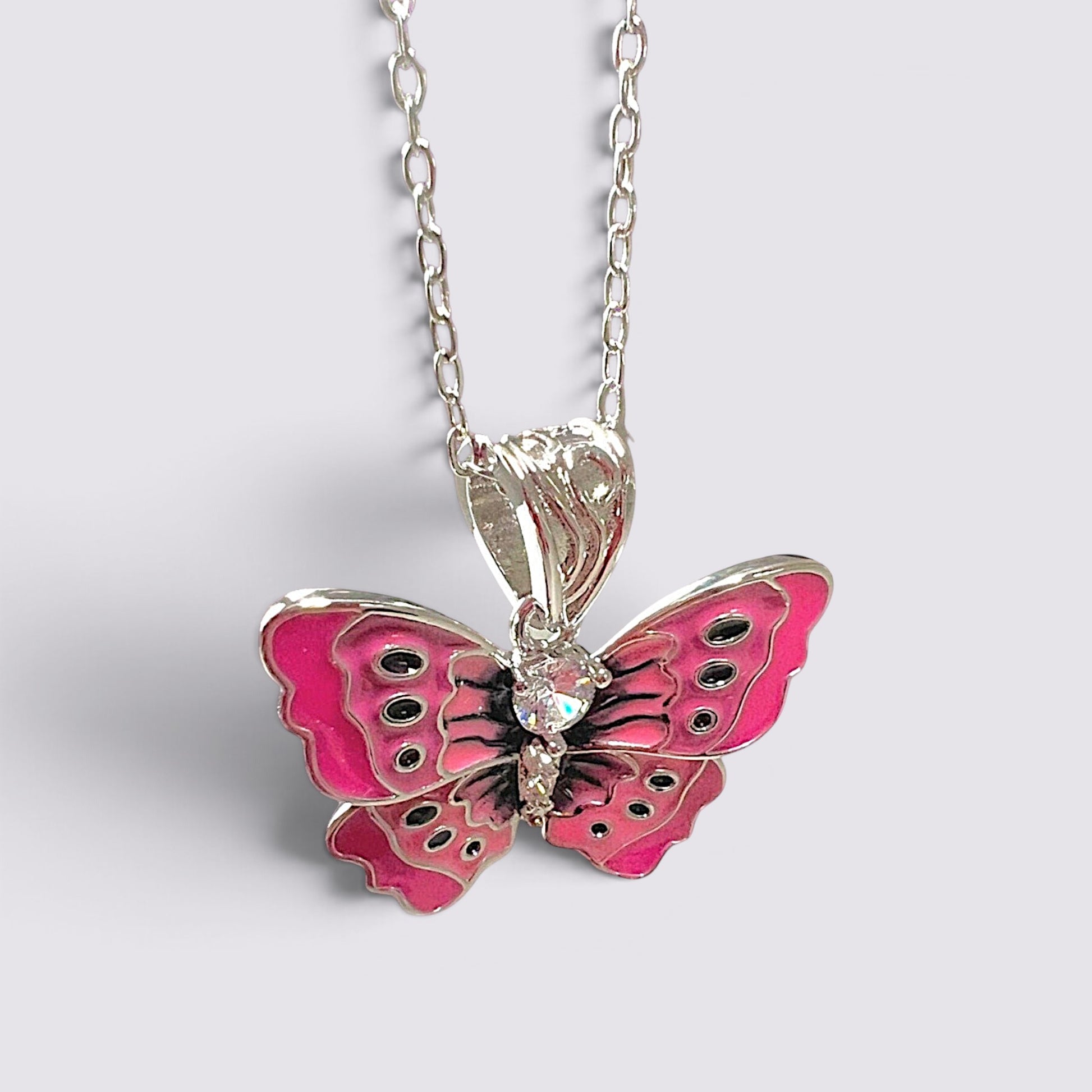 The Fashion Jewels pink enameled butterfly pendant necklace with clear stone accents on a silver-tone chain.