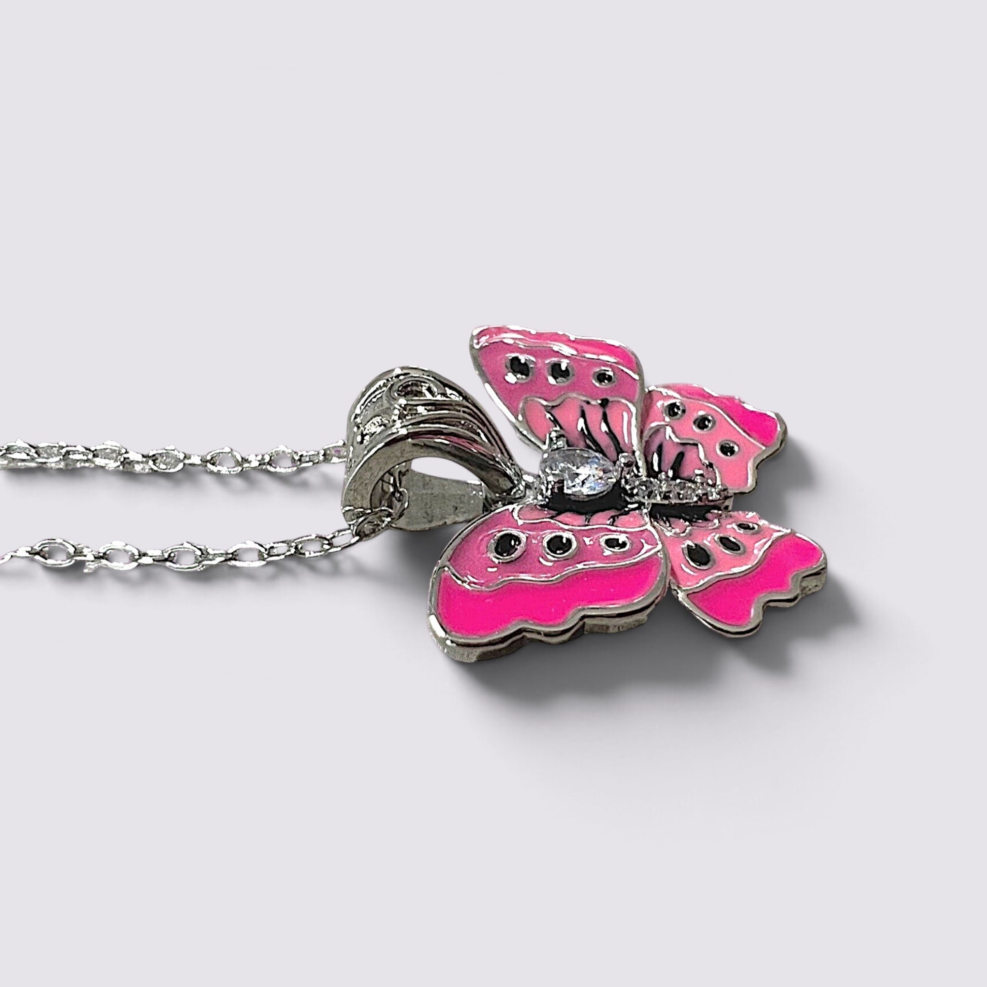 The Fashion Jewels pink enameled butterfly pendant necklace with clear stone accents on a silver-tone chain.