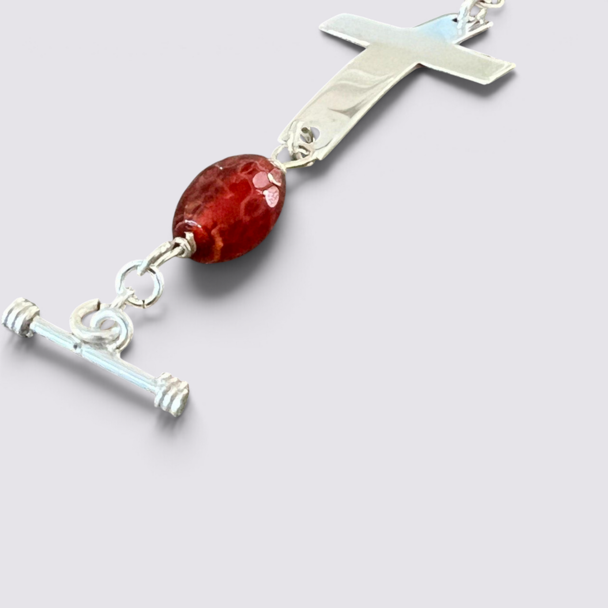 The Fashion Jewels sterling silver cross bracelet featuring faceted red carnelian beads and a secure toggle clasp.