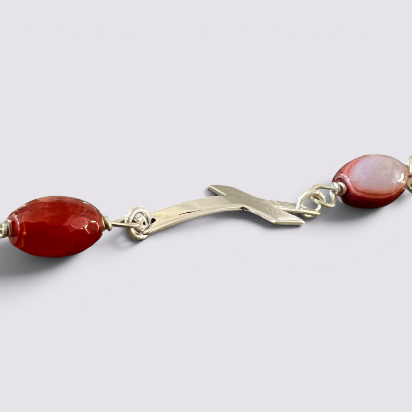 The Fashion Jewels sterling silver cross charm bracelet with faceted red carnelian beads and a toggle clasp.