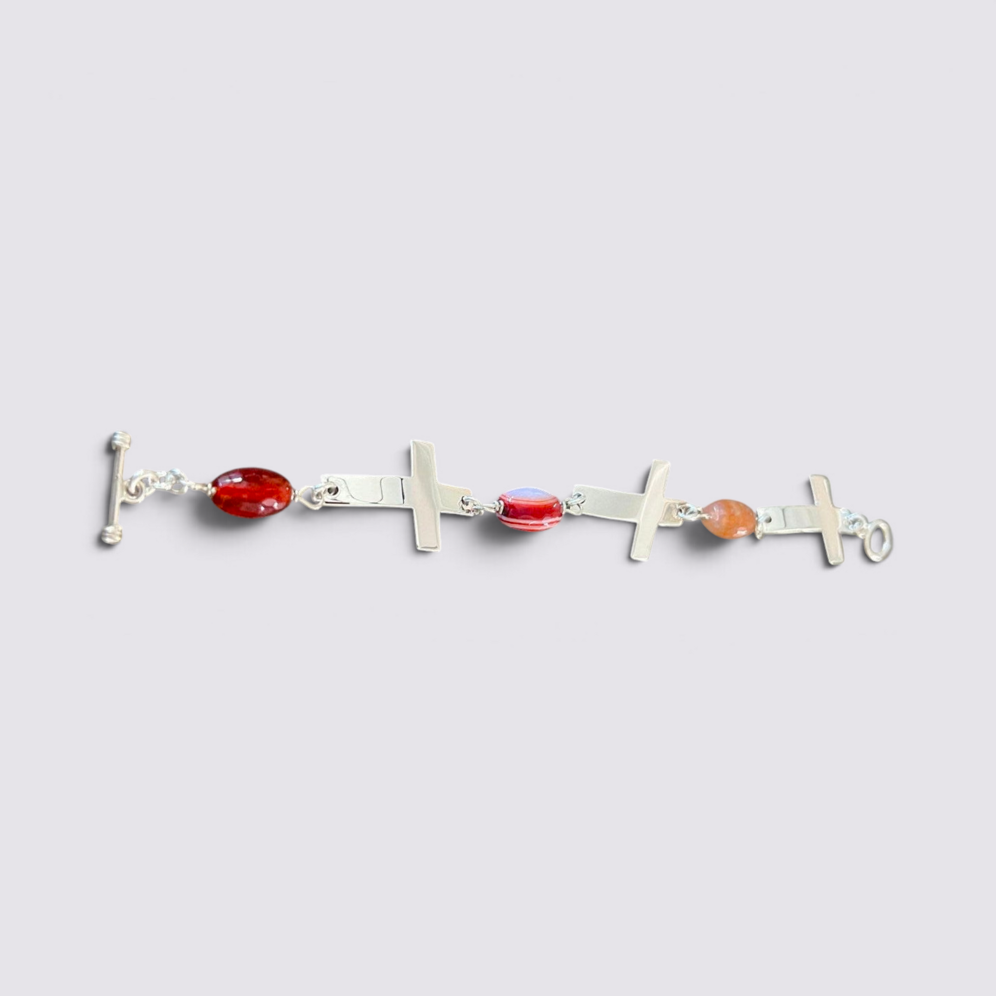 The Fashion Jewels sterling silver cross bracelet featuring faceted carnelian stones and a toggle clasp.