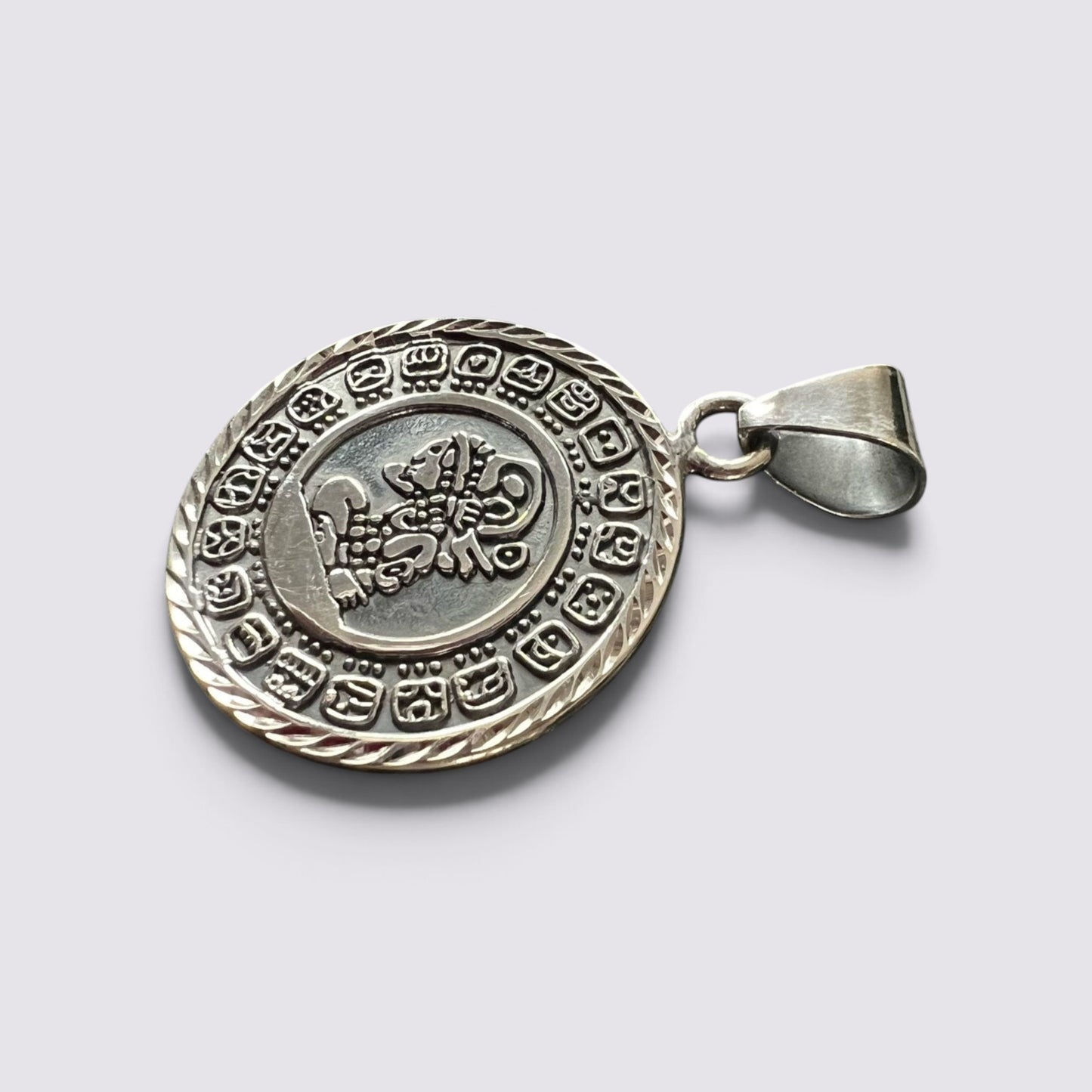 The Fashion Jewels handmade silver Mayan calendar pendant featuring intricate circular engravings and a rope border.