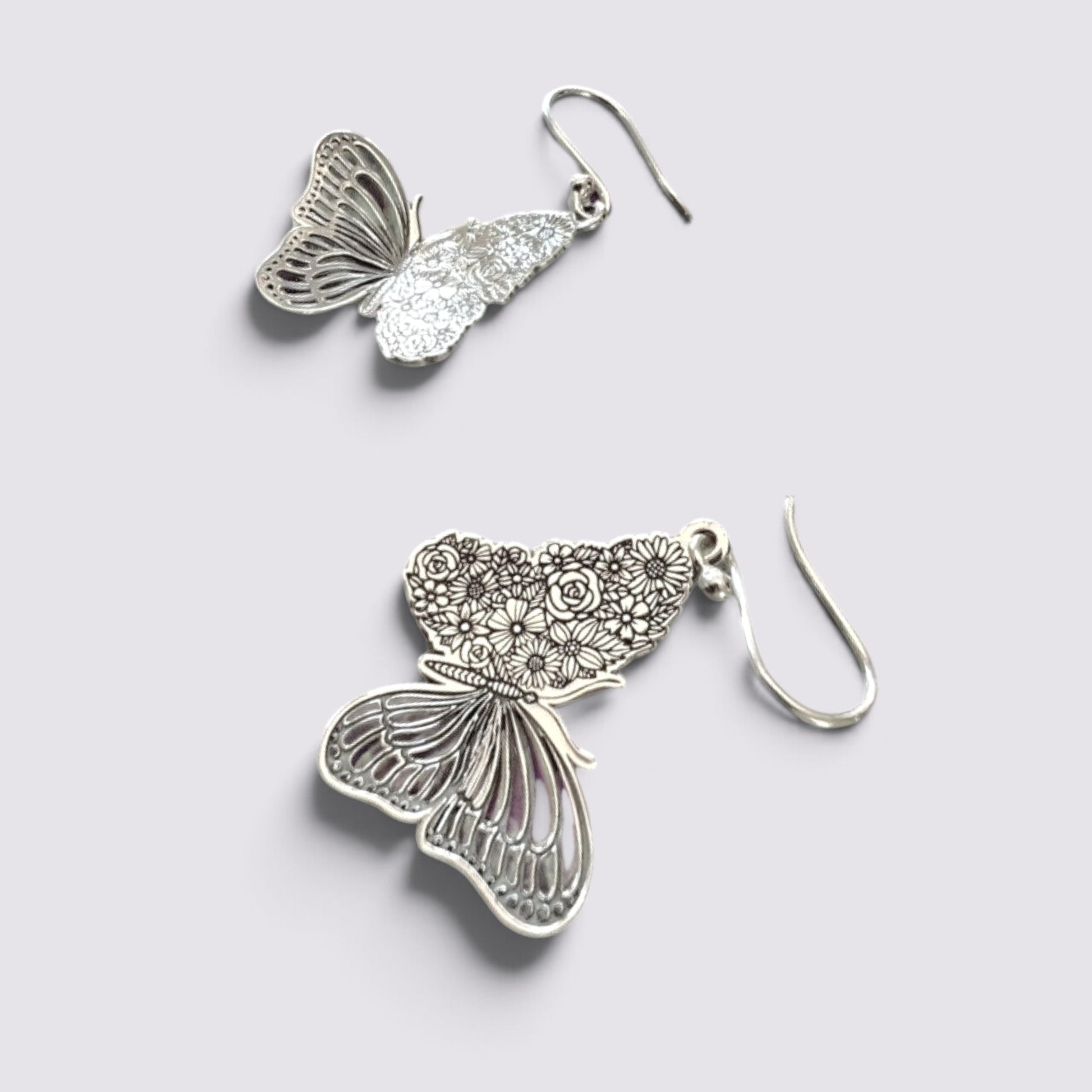 The Fashion Jewels sterling silver butterfly drop earrings featuring intricate floral wing etchings and hook backings.