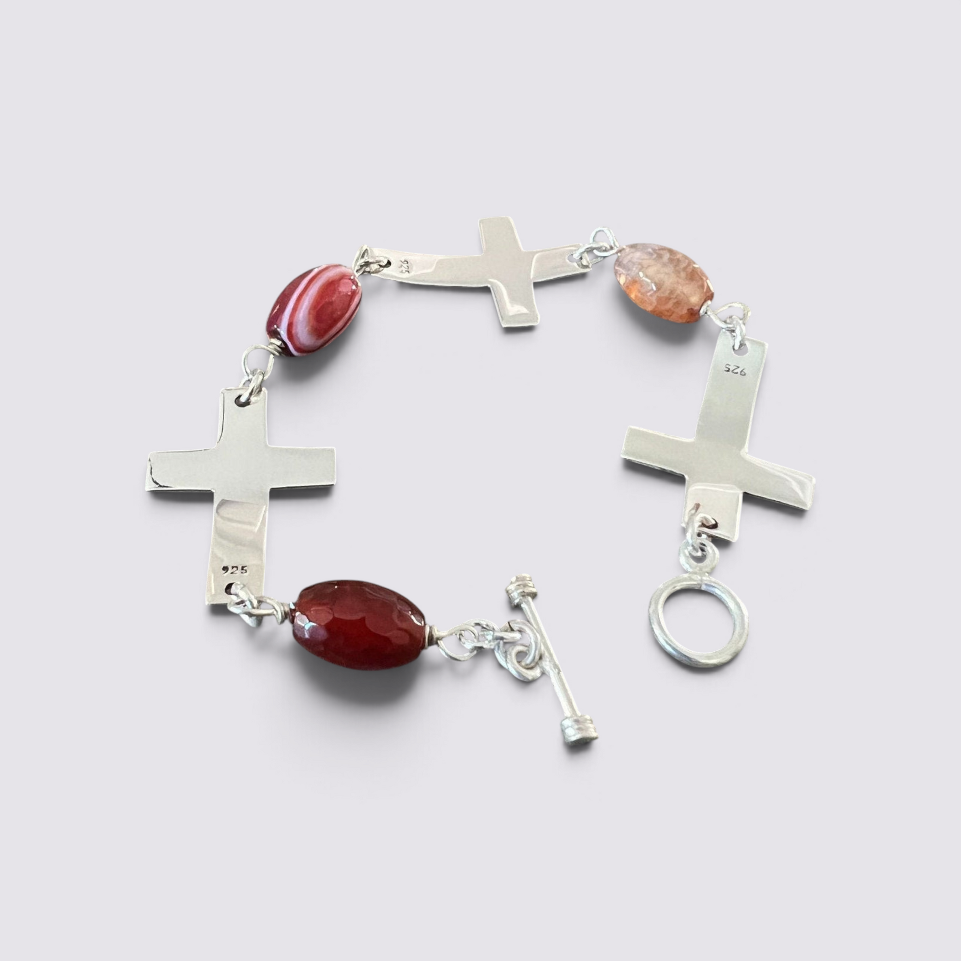 The Fashion Jewels sterling silver cross bracelet with faceted red carnelian beads and a secure toggle clasp.
