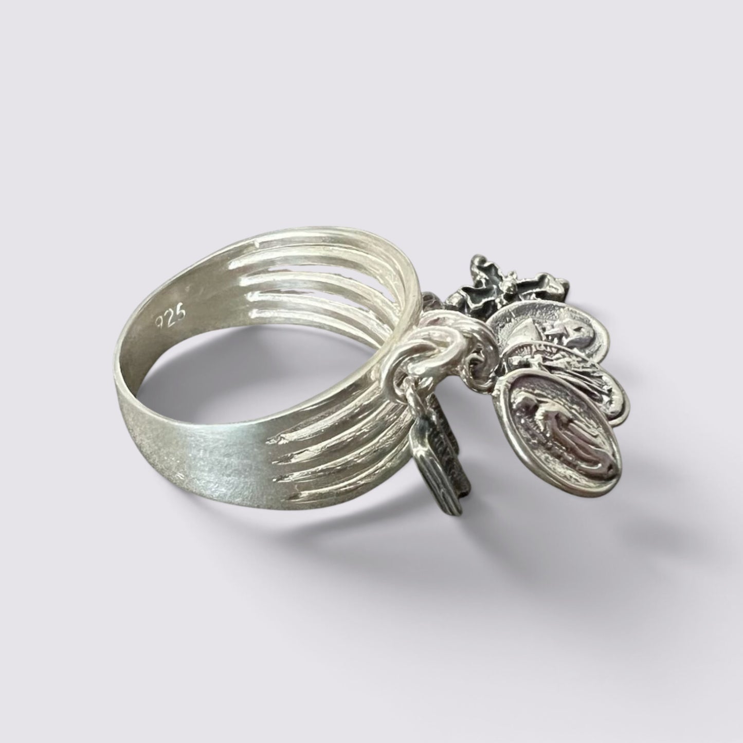 The Fashion Jewels sterling silver ring featuring five hanging religious charms on a multi-band design.