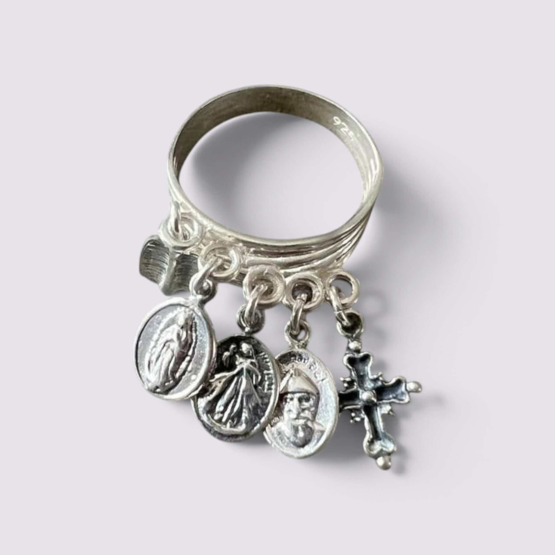 The Fashion Jewels sterling silver ring featuring five hanging religious charms including a cross and saint medals.