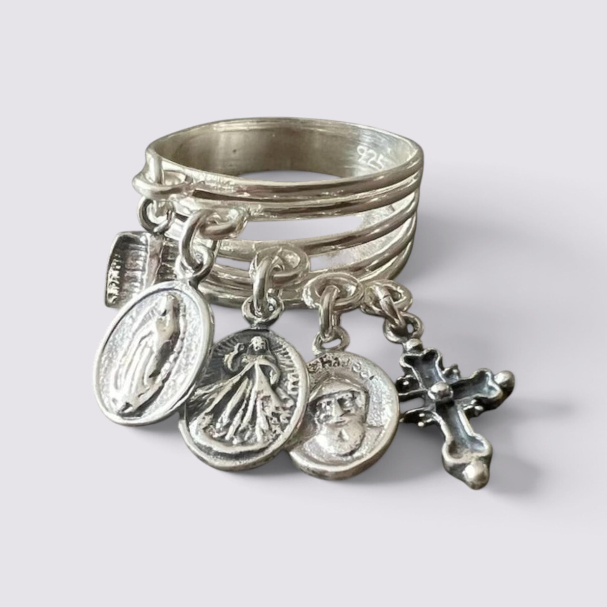 The Fashion Jewels sterling silver ring featuring five hanging religious charms including a cross and oval medals.